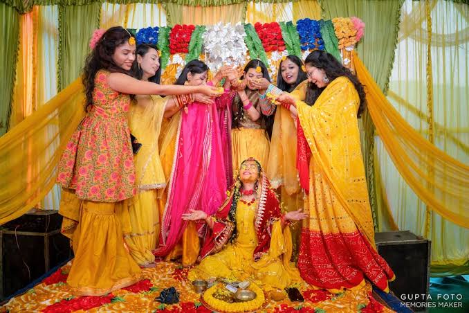 Family celebrating a colourful haldi ceremony